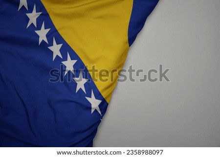 big waving national colorful flag of bosnia and herzegovina on the gray background. macro