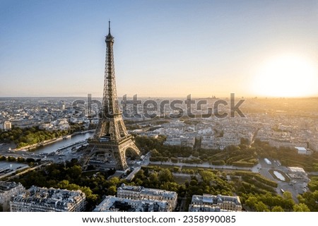 Aerial view of Paris, France, overlooking the famous Eiffel Tower, sunrise in the background.