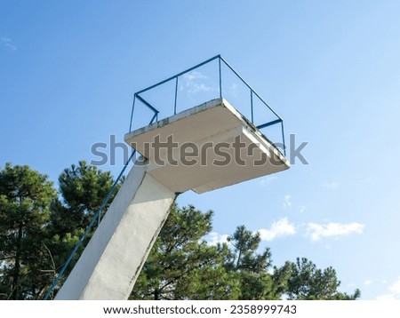  Old diving board. Cement tower on the beach. Against the sky. Resort infrastructure. In a swimming pool