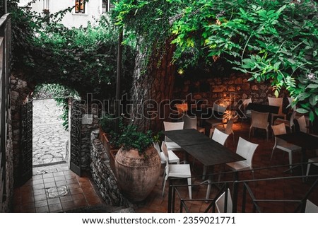 Table setting outdoor. Al fresco cafe with empty chairs in a garden