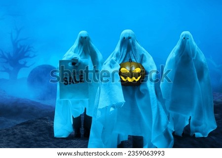 Group of funny white ghost sheet costume holding smile pumpkin glowing face and  shopping bag on graveyard cemetery with fog or smoke background