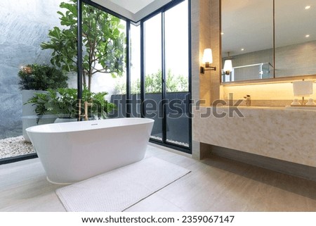 Modern White Bathroom Design with Freestanding Bathtub and Shower Room Installed.