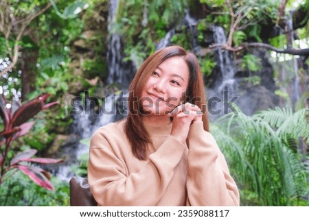 Portrait image of a young woman sitting and relaxing in the garden