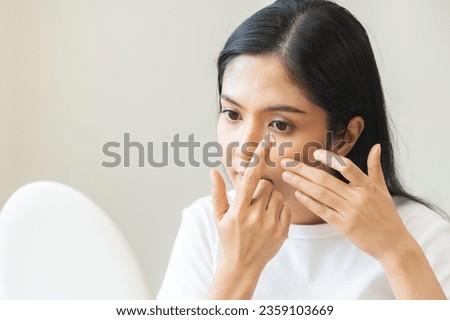 Ophthalmology care, eye sight, vision concept. Asian young woman, female hand holding and putting, wearing soft contact lenses with finger on face, girl looking in mirror at home. Medicine and health. Royalty-Free Stock Photo #2359103669