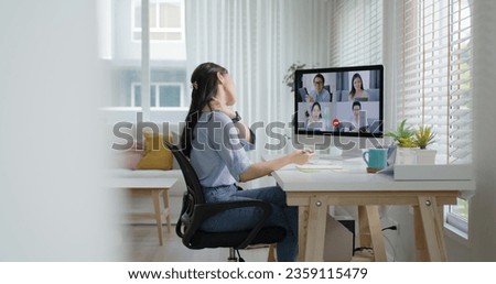 Young adult asia female busy work hard video call online remote group talk stiff neck relief pain ache sit on desk table computer in chronic suffer burnout brownout office syndrome impact at home. Royalty-Free Stock Photo #2359115479