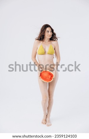 Slender athletic girl in summer swimsuit holds watermelon. Rest, vacation by sea. women Health