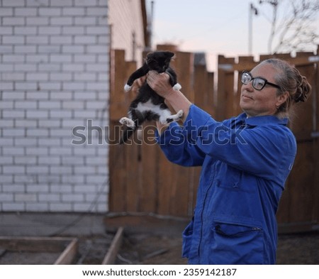 Beautiful middle-aged woman holding a kitten in her arms
