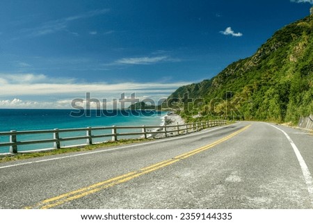 Taitung's famous coastal highway, with the Pacific Ocean on the left and coastal mountains on the right, offers a tranquil and bright experience. Royalty-Free Stock Photo #2359144335