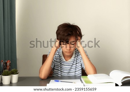 Overwhelmed student with low motivation to learn. The student with difficulties study issues over textbook, workload too much school assignment. difficulties studying in teenager concept. Royalty-Free Stock Photo #2359155659