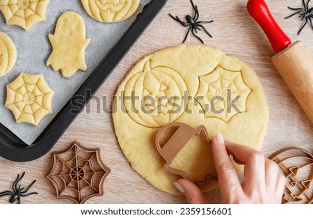 Preparation of festive cookies for baking in the oven. Ready-to-bake Halloween cookies shaped like pumpkins and ghosts