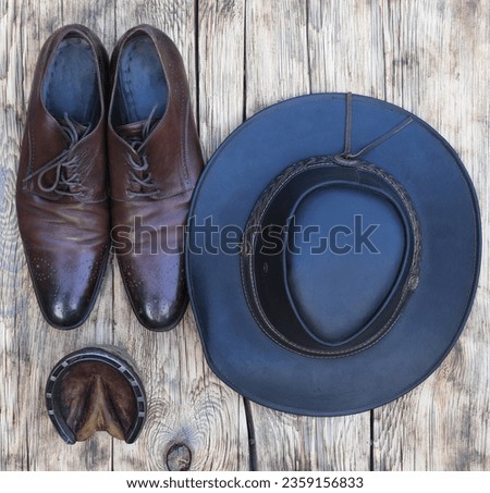 cowboy hat and leather shoes on old wooden background