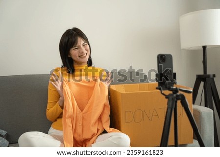 Beautiful asian woman talking with camera for broadcast and live video to invite people to donate things to the poor people.