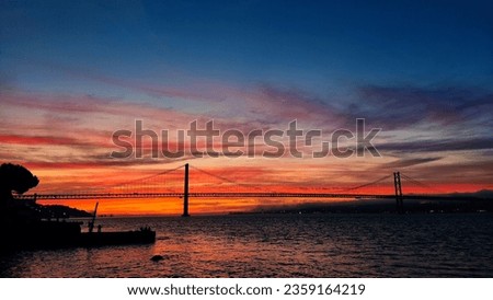 Beautiful sunset in Lisbon. 25th april bridge in the golden hour with no fliter. Royalty-Free Stock Photo #2359164219