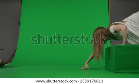 Full-size side view green screen chroma key shot of a posessed female, woman figure, ghost, poltergeist, zombie crawling over an obstacle. The ring reference. Chroma key.