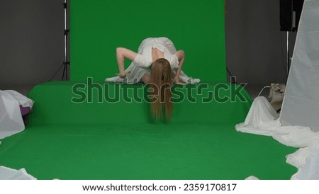 Full-size green screen chroma key shot of a posessed female, woman figure, ghost, poltergeist, zombie crawling over an obstacle towards the camera. The ring reference. Chroma key.