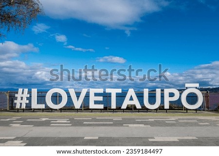 Hashtag Love Taupo sign in front of Lake Taupo in New Zealand. Royalty-Free Stock Photo #2359184497