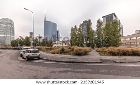 Panorama showing skyscrapers and towers from park with outumn treea and green lawn timelapse. Located between Piazza Gae Aulenti and the Isola district. Traffic on a road. Milan. Italy
