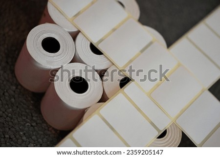 Labels for direct thermal or thermal transfer printing. Blank sticky label roll for thermal transfer printing price criss. Rolls of white labels isolated. 	