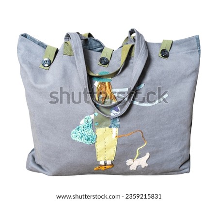 full closed handmade gray canvas tote bag with color girl and dog appliqued isolated on white background