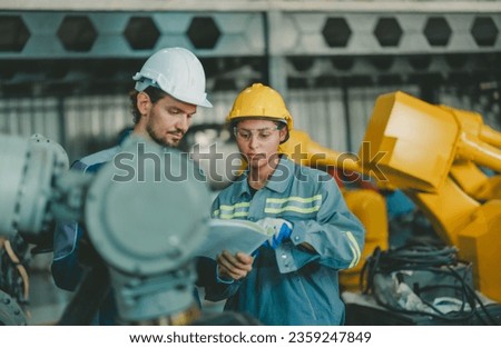 ndustrial robotic technicians virtually inspect, assess reliability of printed circuit assembly boards in robotic arm. Identifying errors, impaired, wear then record and report issues to supervisors Royalty-Free Stock Photo #2359247849