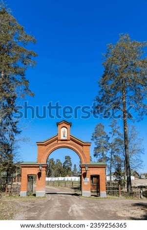 the gate to the church in the woods on the road. Landscape. Spring sunny day