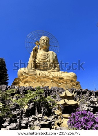 Golden Buddha statue in Van Hanh Pagoda, Da Lat, Vietnam. Beautiful blue sky. Royalty-Free Stock Photo #2359256793