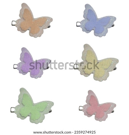 Butterfly hair clips with 6 different colors of glitter on a white background. Royalty-Free Stock Photo #2359274925