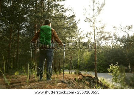Mature man backpacker enjoying life trekking to explore outdoors Royalty-Free Stock Photo #2359288653