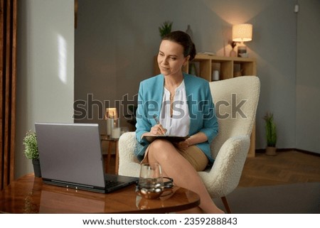 Friendly smiling woman psychologist looking at laptop computer screen Royalty-Free Stock Photo #2359288843