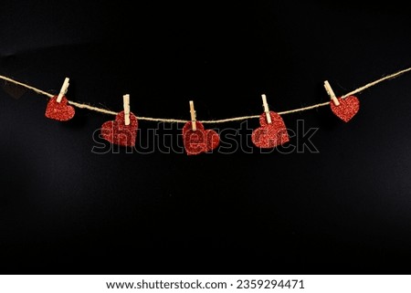 hearts on a string on a black background, selective focus, copy space. Love concept.
