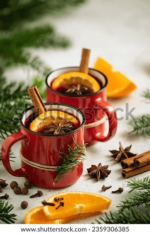 Christmas card with mulled wine, spices and oranges surrounded by fir branches