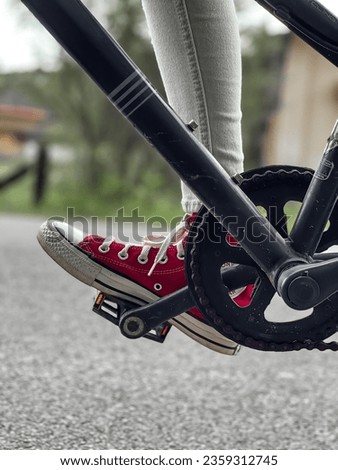 The picture of someone riding a bicycle wearing converse shoes