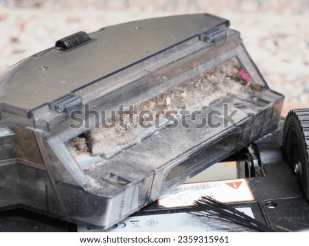 a dust container collected by a robot vacuum cleaner Royalty-Free Stock Photo #2359315961