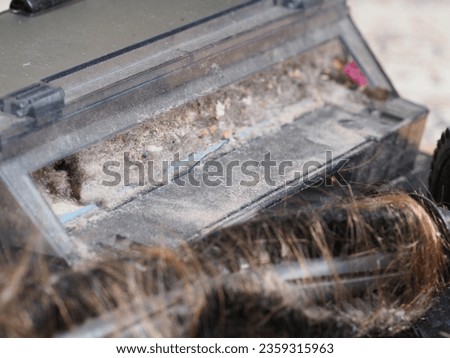 a dust container collected by a robot vacuum cleaner Royalty-Free Stock Photo #2359315963