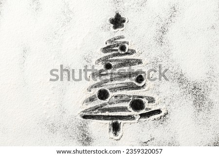 winter holidays and cooking concept - close up of christmas tree drawing on powdered sugar or flour on black background