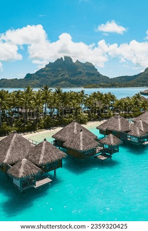 Aerial drone shot of the tropical island Bora Bora in French Polynesia with a resort, hut, beaches and palm trees  Royalty-Free Stock Photo #2359320425