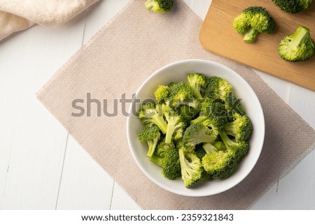 sliced broccoli in white bowl on the table,edible green plant in the cabbage family,whose large flowering head.Top view Royalty-Free Stock Photo #2359321843