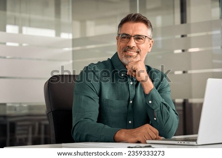 Happy mature business man of middle age, confident entrepreneur or bank manager, 45 years old executive, mid aged businessman investor sitting at work desk in office looking aside. Copy space. Royalty-Free Stock Photo #2359333273