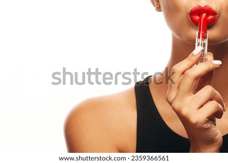 Beauty Cosmetics, Fashion Make-up concept. Close up portrait of charming young woman with opened lipstick in her hand. Short haircut, healthy skin. Copy-space. Studio shot
