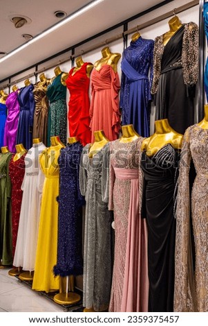 colorful evening dresses on metallic gold female mannequins lined up in front of the wall in women clothing store, retail in Kayseri Turkey, Kitsch in fashion