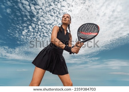Padel tennis player with racket. Woman athlete with paddle racket on court outdoors. Sport concept. Download a high quality photo for the design of a sports app or web site.