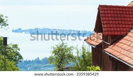 House on background of Lindau island in Lake Constance, Germany, Europe. View of Bodensee in summer, tourist attraction of Bavaria. Travel and tourism theme. Royalty-Free Stock Photo #2359385429