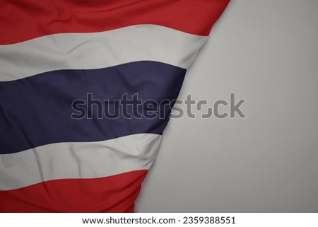 big waving national colorful flag of thailand on the gray background. macro