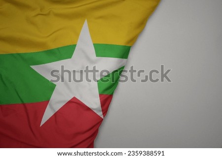 big waving national colorful flag of myanmar on the gray background. macro