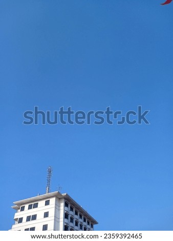 a tall building taken from below with a clear sky in the background