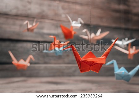 Colorful many origami paper cranes on wooden background Royalty-Free Stock Photo #235939264
