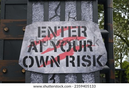 A picture of enter at your own risk sign at entrance.