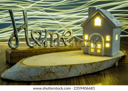 metal home sing ceramic house with bright wavy light on in the background