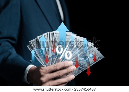 Businessman holding money with percentage icon and up and down arrow icon with graph indicator, financial interest rates and mortgage rates. Interest Rates Stocks Finance Ratings Mortgage Rates.