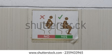 This is a photo of the symbol of the prohibition against squatting in a sitting toilet